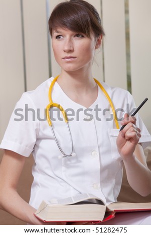 portrait of young female doctor with a book