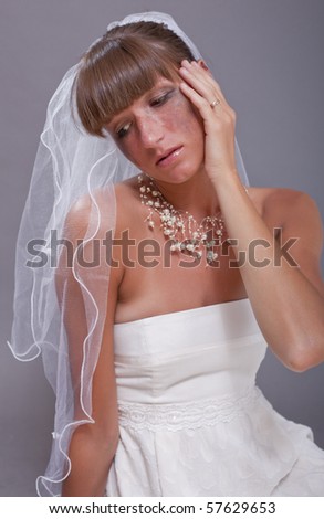 portrait of crying bride over grey background