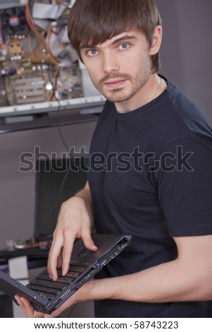 male technician in black shirt fixing computer problems