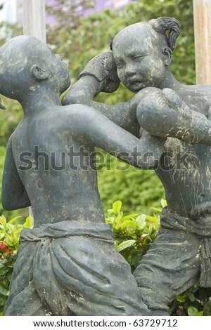 sculpture of young fighting girls on the street in thailand