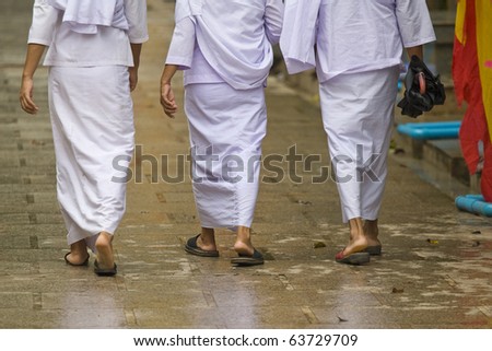 buddhist religious women in white robes walking on the street