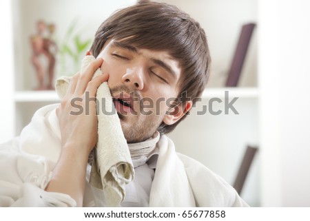 toothache - sick man covering with towel his cheek