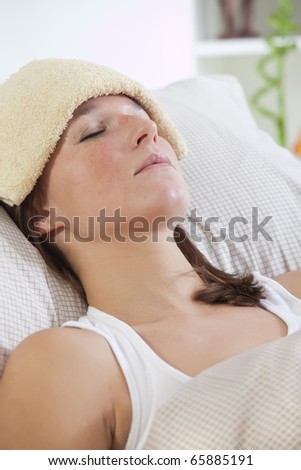 sick woman in bed with towel on forehead