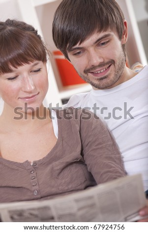 couple reading newspaper on the sofa in apartment