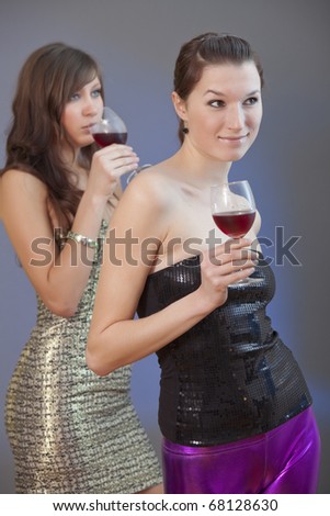 two party girls with drinks on disco - shot over grey background