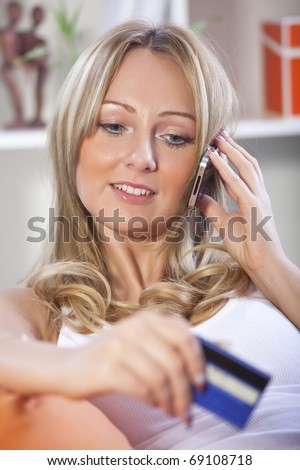 happy blond woman making a order on mobile phone at home