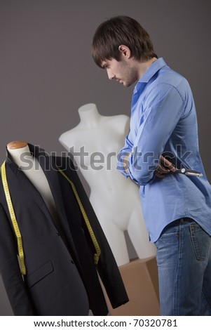 young male tailor working on business suit