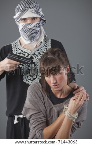 female hostage and hijacker with gun over grey background