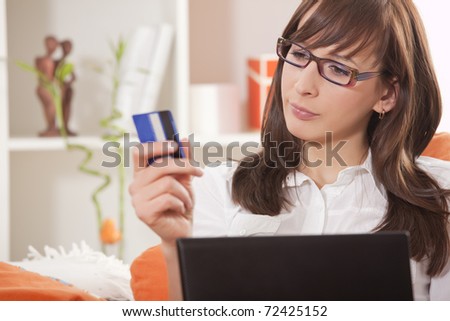 woman with credit card and laptop thinking about internet shopping