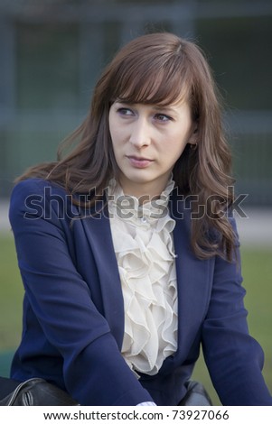 portrait of sad woman in elegant jacket sitting outdoor