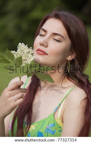 happy young woman in field with flower in her hands