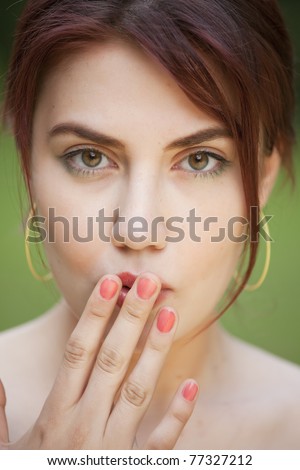 portrait of shy young woman with her hand covering mouth