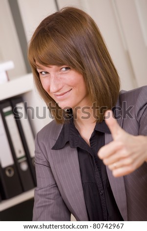 woman in business suit with thumb up by office work