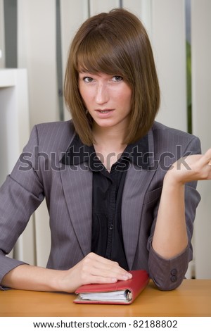 young businesswoman or secretary with diary in stress by office work