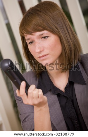 frustrated businesswoman holding phone waiting for call