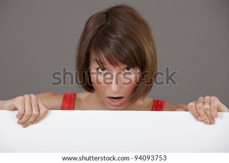 surprised woman with a white banner over grey background