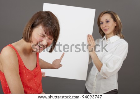 woman laughing about a businesswoman which holding a blank white board - for personal message or sales offer