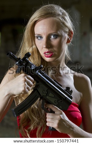 Gun woman in red dress with automatic gun in old fabric
