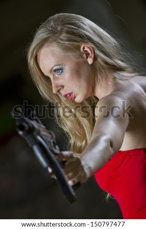 Sexy spy in red dress and machine gun in old fabric