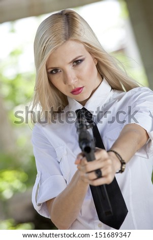 angry woman in white shirt and tie aiming the gun in the camera