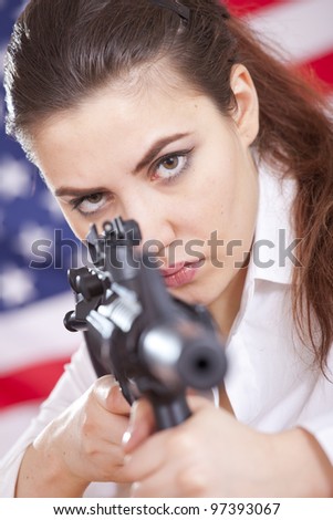 young woman over american flag aiming with machine gun