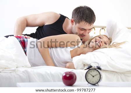 Couple in Bed - smiling man embracing happy woman