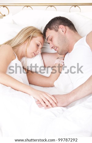 romantic couple in nightwear sleeping in bed
