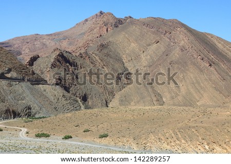 Eroded land under blue sky and white clouds, Atlas mountains, Morocco