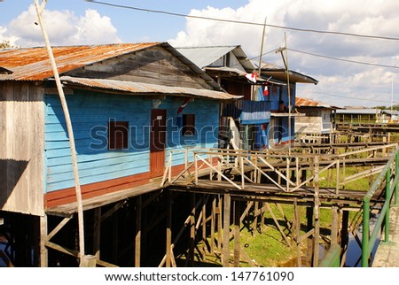 Houses on stilts rise above the polluted water in Islandia Peru