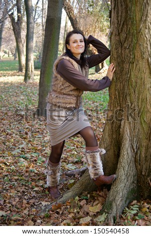 Autumn woman wearing leg warmers leaning tree