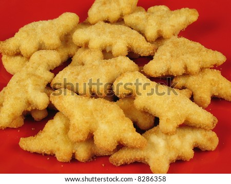A plate of dinosaur-shaped chicken nuggets copes with extinction issues as they suffer the effects of deep frying.