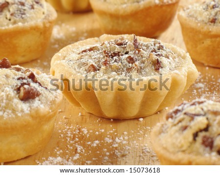 Pecan tarts with a light sprinkle of confectioner\'s sugar.