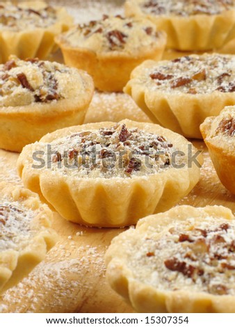 Sweet pecan tarts with a light sprinkle of confectioner\'s sugar.