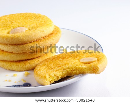 Plate of Chinese almond cookies with a bite missing.