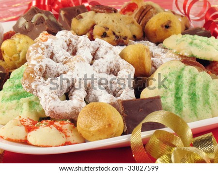 Tempting plate of rosettes, chocolate fudge, spritz cookies, tea cakes, and more.