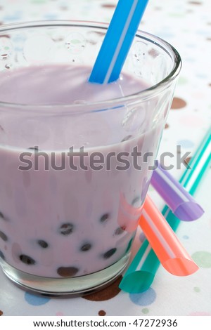 Glass of blueberry flavored pearl milk tea.