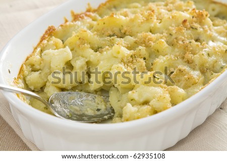 Baked macaroni and cheese made with pesto sauce, provolone cheese, and mozzarella cheese, then topped with bread crumbs.