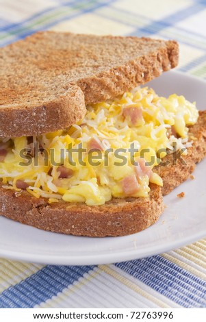 Ham, eggs, and cheese sandwiched between two slices of toasted wheat bread.