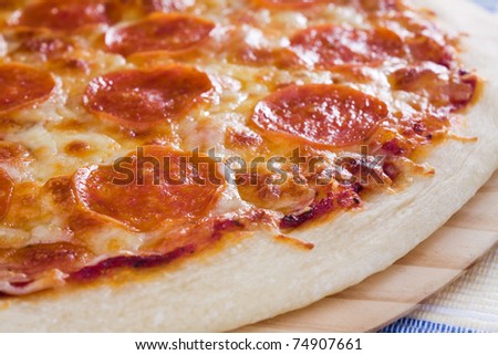 Thin crust pizza topped with pepperoni slices and mozzarella cheese.