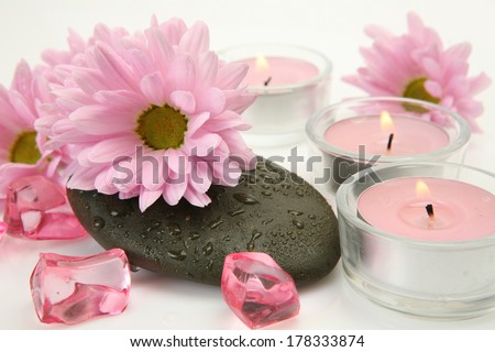 Burning candles and pink flowers