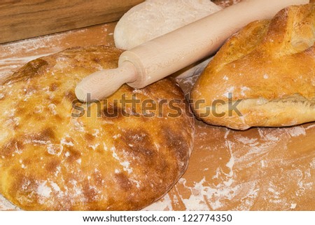 Bread baking scene with rolling pin on a wooden board
