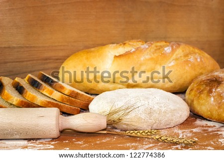 Baked baguette and bread on wooden board