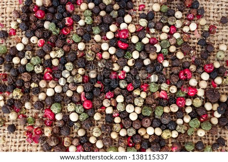 Background of peppercorn melange - black peppercorns, white peppercorns, red peppercorns, and green peppercorns.