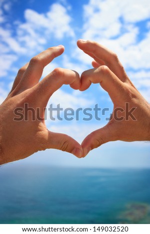 hands make heart sign over beautiful sky