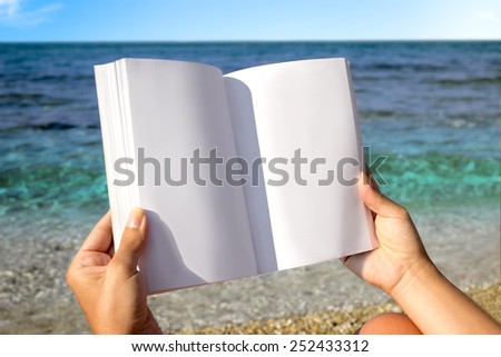 Reading book in the beach, hands holding book with blank pages, copy space for text