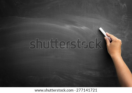 Blank blackboard / chalkboard, hand writing on black chalk board holding chalk, great texture for text.