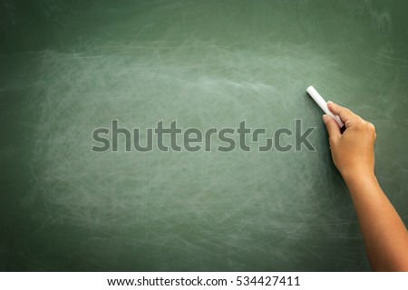 Green chalkboard with hand holding chalk, background for copy space