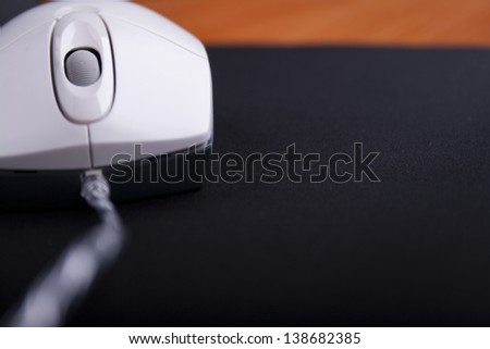 white mouse and black pad on wooden table