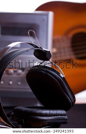 black headphones close up and stereo system with guitar background
