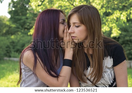 Two young girls are whispering